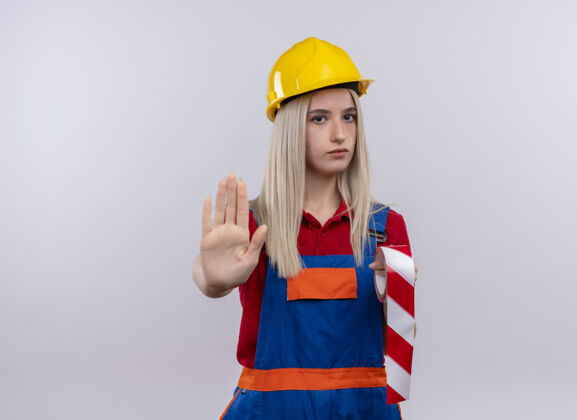 磁带穿着制服的年轻金发工程师建筑女孩拿着透明胶带伸出手 在有复印空间的白色隔离墙上做着“不”的手势手苏格兰制服