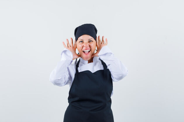 皮肤护理穿着制服的女厨师 围裙手拉着耳朵 看起来很疯狂 前视图烹饪女性水疗