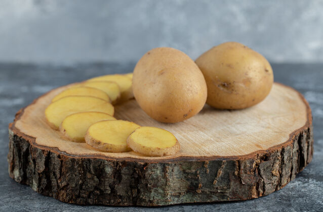 半木版土豆片和整片土豆的特写照片健康皮切割