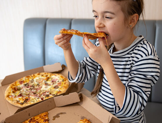 午餐小女孩午餐吃开胃的奶酪披萨女孩切片美味