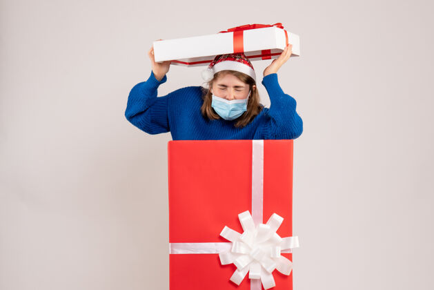 圣诞节年轻女子躲在白色的礼品盒里年轻女性流行帽子