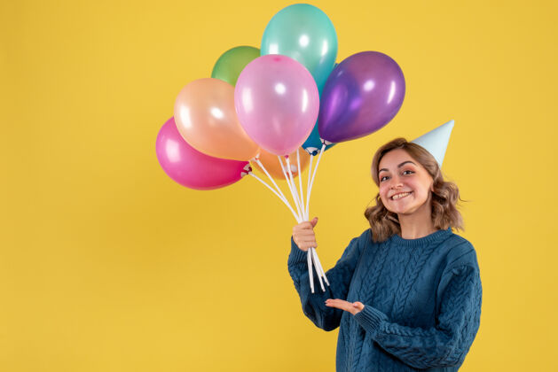 女人手持黄色气球的年轻女性观点年轻的女性生日