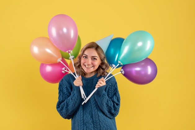 乐趣手持黄色气球的年轻女性庆祝观点生日