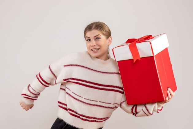 情绪年轻的女性拿着礼物在白色的盒子里包购物者购物