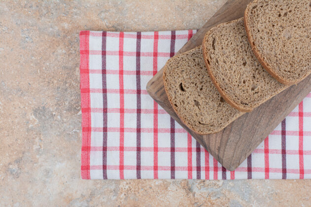 桌布用桌布把黑面包片放在木板上谷类食品面包房黑麦