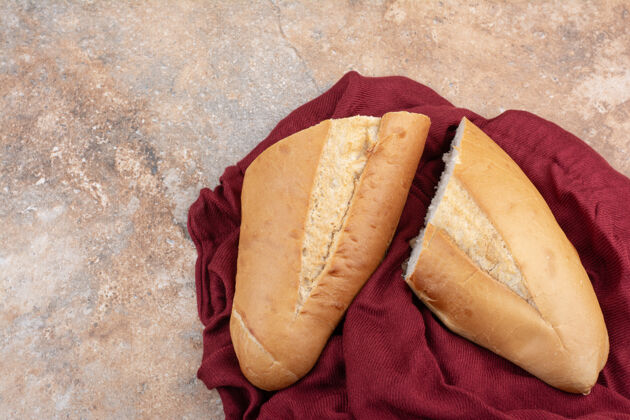 切的新鲜的面包和大理石背景上的红色桌布桌布面包面包