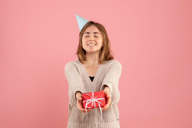 人年轻的女性拿着粉红色的圣诞礼物举行年轻女性情感