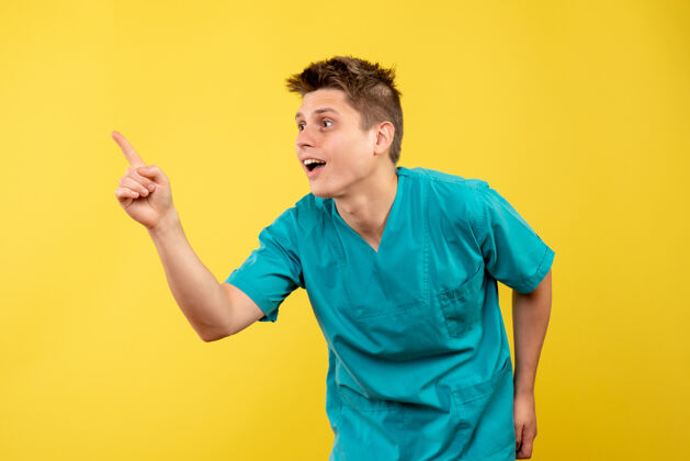 医学正面图黄色背景上穿着医疗服的年轻男医生年轻男性医生成人医学