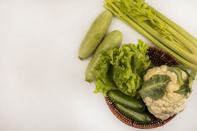 食品健康蔬菜的俯视图 如莴苣 花椰菜和黄瓜 放在一个桶里 还有芹菜和西葫芦 隔离在白色的墙上 留有复制空间桶生菜花椰菜