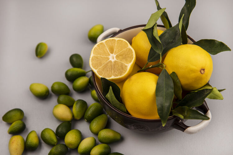 水果新鲜黄色柠檬的顶视图 叶子放在碗上 金盏花被隔离在白色的墙上厨房块切片