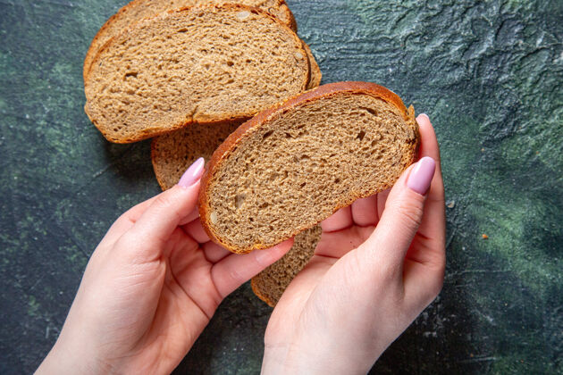 面包俯视图黑色面包面包与女性的手在黑暗的桌子上深色面包面包