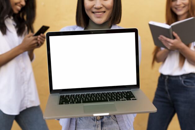 多样性不同的美女拿着一个笔记本电脑模型模型女孩年轻