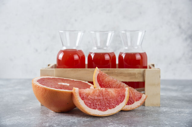 健康装着新鲜葡萄柚汁的玻璃罐装在木箱里 里面装着水果片果汁水果食物