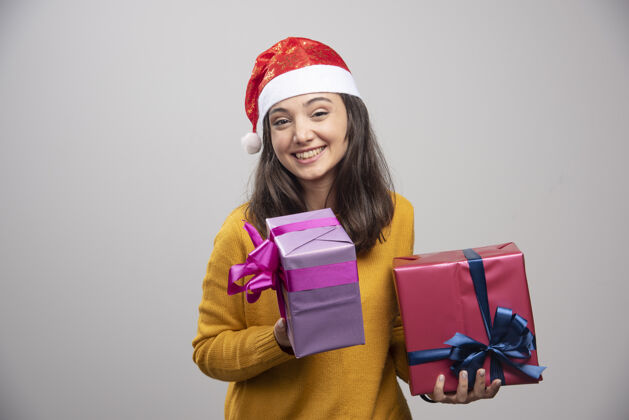 女性戴着圣诞帽拿着礼盒的年轻女子模型惊喜乐趣