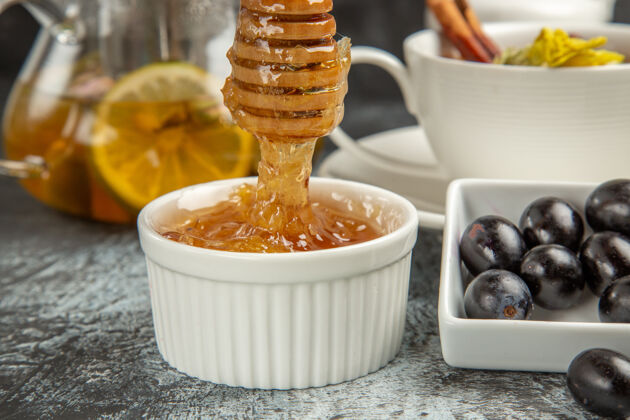 甜点前视图甜甜的蜂蜜茶和橄榄在黑暗的表面早餐小吃杯子早上
