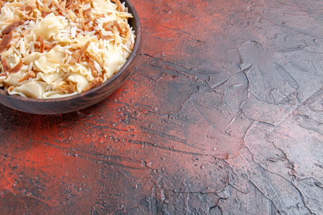 前面前视图切碎煮熟的面团 米饭放在深色的面食上油漆颜色墙