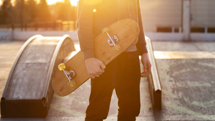 滑板带滑板的少年特写镜头爱好年轻人滑板