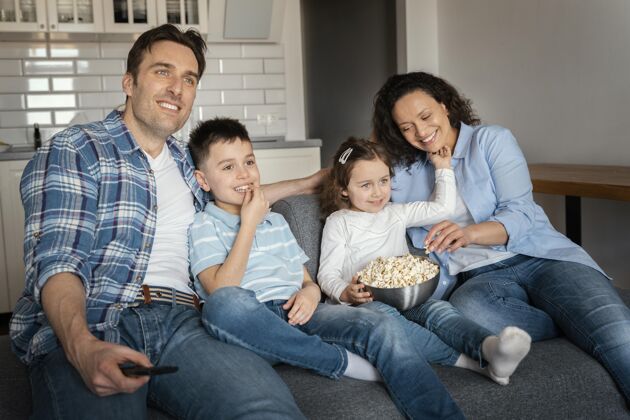 中镜头中景家庭看电视在家里男人男孩