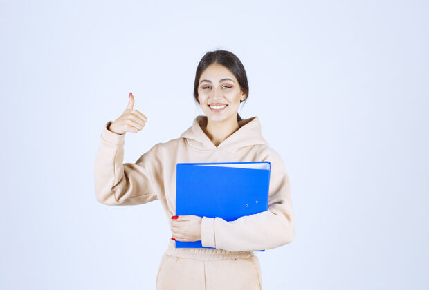 商业助理拿着一个蓝色文件夹 上面写着“享受”的牌子交易项目女人