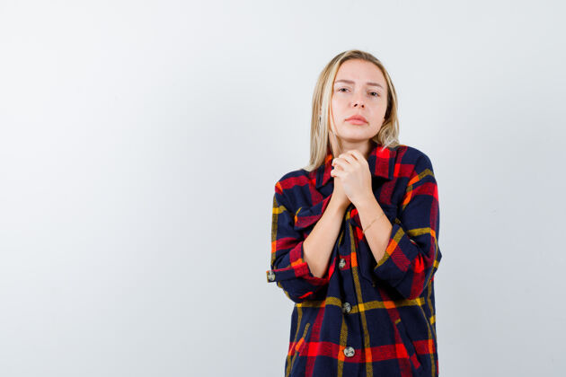 人年轻女士穿着格子衬衫 双手紧握祈祷 看上去很平静 正前方女士衬衫前面