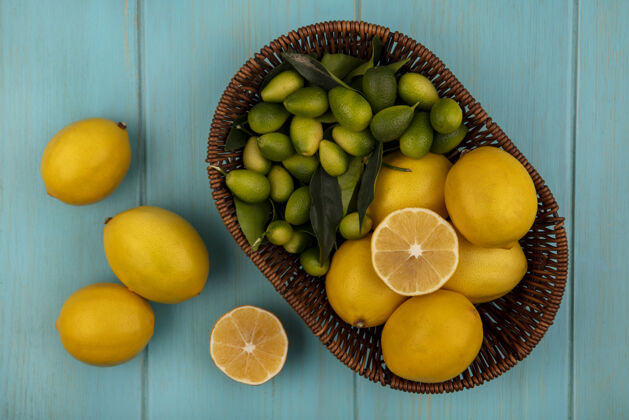 食物新鲜水果的顶视图 如柠檬和金盏花在桶上 柠檬被隔离在蓝色的木墙上人景观膳食