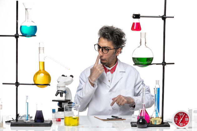 视图正面图穿着白色医疗服的中年化学家拿着溶液坐着人医生技师