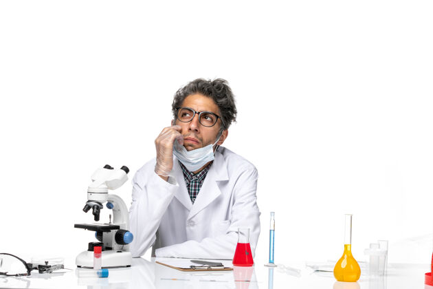 化学正面图穿着特殊白色西装的中年科学家围坐在桌子旁 拿着解决方案科学特殊男性