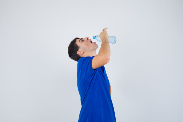 肖像年轻人穿着t恤喝水 看起来口渴少饮用童年