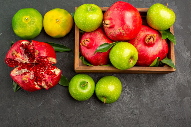 颜色顶视新鲜石榴与橘子和苹果在黑暗的表面成熟的水果颜色新鲜饮食梨