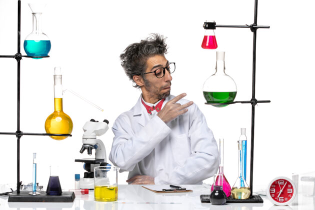 病毒前视图穿着白色医疗服的中年化学家坐在那里 用溶液修好他的西装专业化学观点