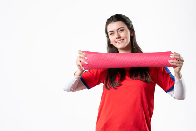 运动正面图穿着运动服的年轻女性 带瑜伽垫白墙垫子训练人物