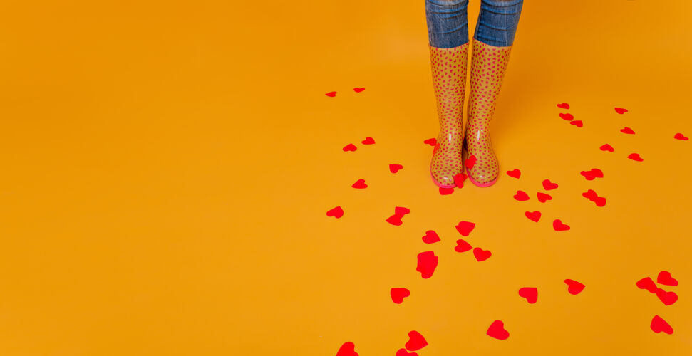 室内一个穿着胶靴的女人站在地板上 满心欢喜一个穿着黄色胶鞋 身材匀称的女人在情人节摆姿势的摄影棚镜头冷浪漫休闲
