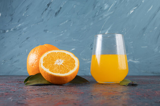 多汁橙子片和一杯果汁 放在混合桌上有机橙子平铺