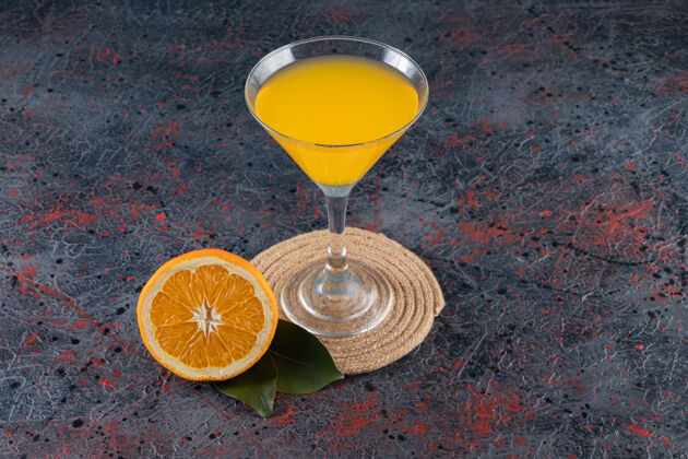 营养把橙子片和一杯果汁放在三角架上 放在混合桌上可口橙子水果