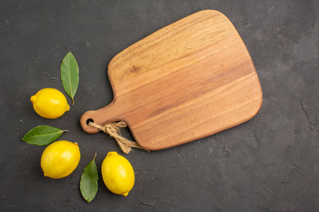 柠檬顶视图新鲜的酸柠檬衬上深色的餐桌水果 柠檬黄 柑橘黄顶部蔬菜砧板