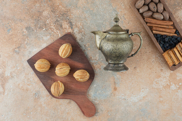 美味古老的水壶和甜甜的圆形饼干在大理石背景上糕点水壶面包房