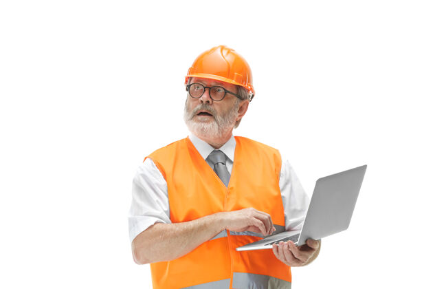 工人穿着建筑背心 戴着橙色头盔 带着笔记本电脑的建筑工人人员男性计划