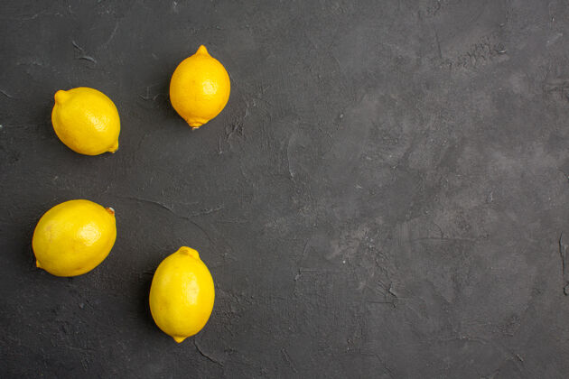 平铺顶视图新鲜柠檬排在一张深色的桌子上柑橘黄色的水果为文字的自由空间新鲜柠檬食物顶部