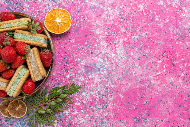 质地美味的华夫饼与新鲜的红色草莓在粉红色的表面俯瞰华夫饼饼干新鲜