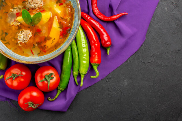 豌豆俯瞰美味的肉汤和新鲜蔬菜在黑暗的桌子上照片菜色辣椒午餐深色