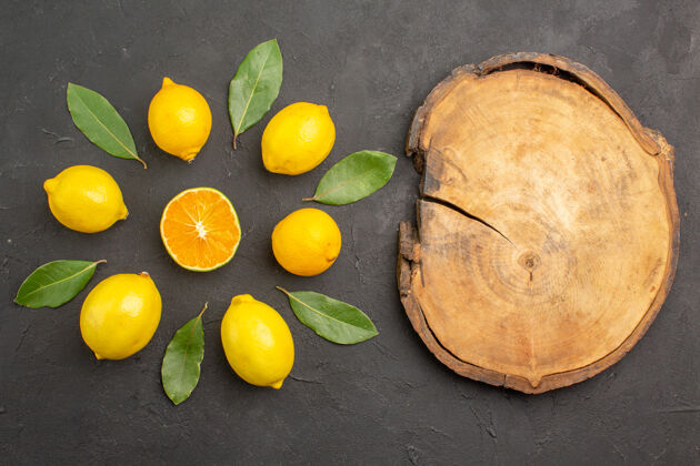 黄色顶视图新鲜的酸柠檬衬在深色的餐桌上 橙黄色的柑橘类水果顶部食物深色