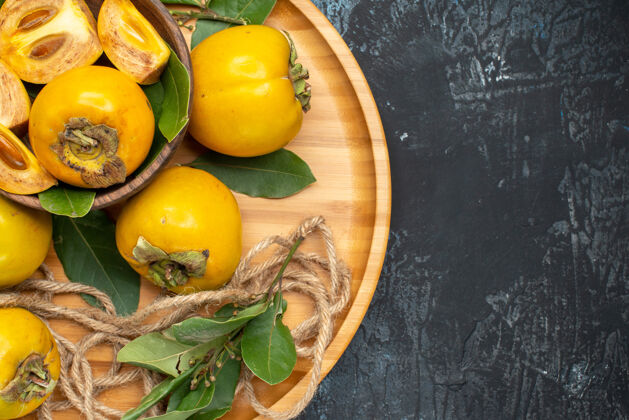 成熟顶视图新鲜甜甜的柿子放在深色桌上熟透的水果食物胡椒味道