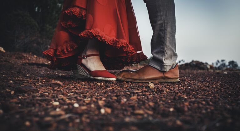 结合一个穿着红裙子和红鞋子的女人在一个男人面前男性成人激情