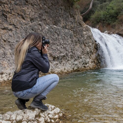 摄影师拍大自然照片的女人旅游高山瀑布