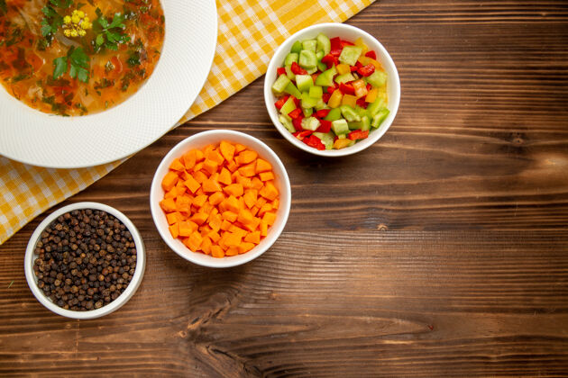 蔬菜俯瞰美味的蔬菜汤与切片蔬菜在棕色的木制桌子上汤食品蔬菜调味料顶风景晚餐
