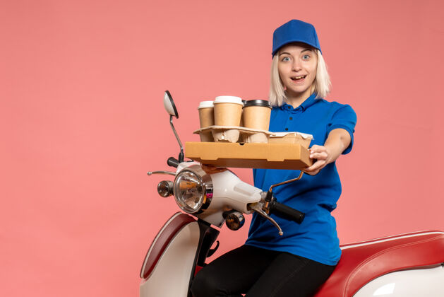 服务前视图骑在自行车上的女信使与咖啡杯上的粉红色咖啡车辆女快递
