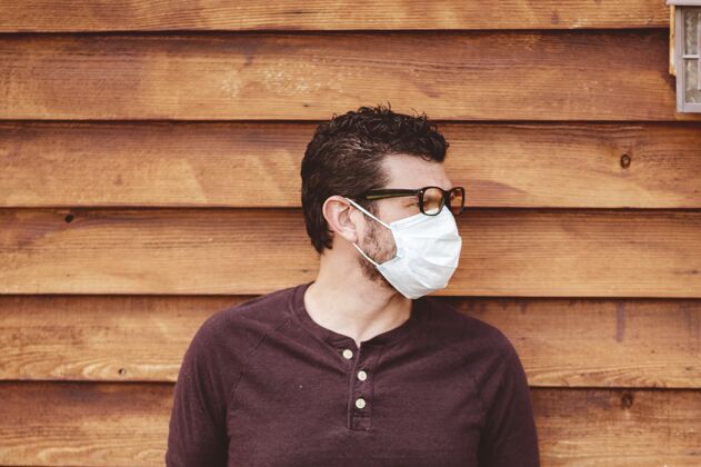 医疗在木墙前戴着眼镜和卫生口罩的男人眼镜卫生衬衫