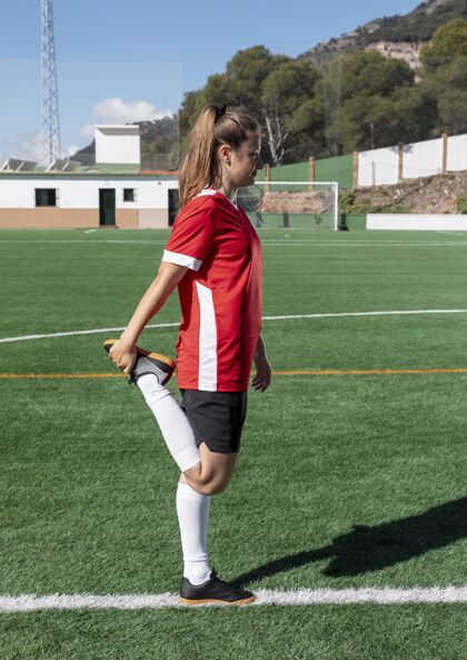 训练在足球场上伸腿的女人全速运动活跃