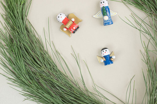 装饰品圣诞玩具和米色表面的树枝天使节日节日