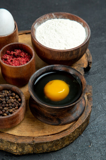 杯子前视图灰色空间上不同的面粉和鸡蛋调味品生的健康餐